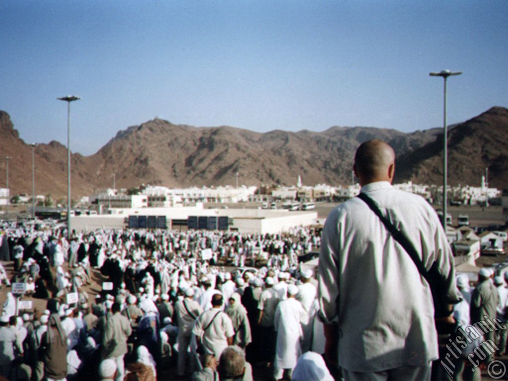 The Mounts Uhud, the field of Battle of Uhud (the second battle of the Prophet Muhammad [saaw] against unbelievers); the cemetery of the first muslims died for Islam during the Battle of Uhud (located in the middle) and the pilgrims visiting these places in Mecca city of Saudi Arabia.
